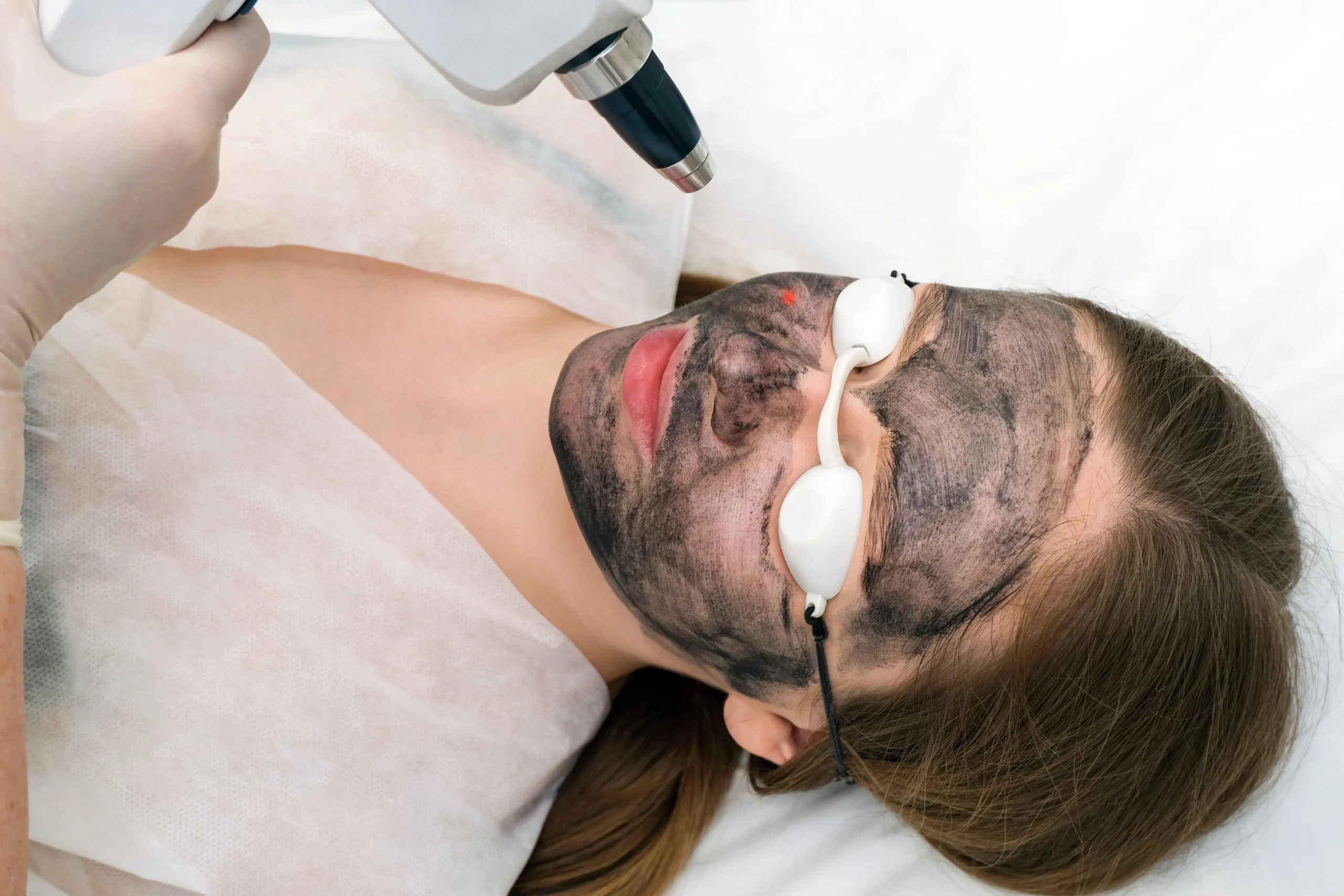 Man resting on a treatment bed while a facial mask is applied