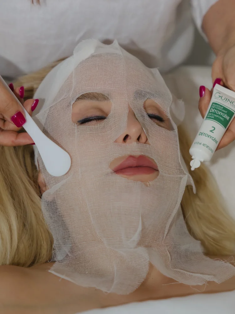Facial mask being applied to a client with a brush