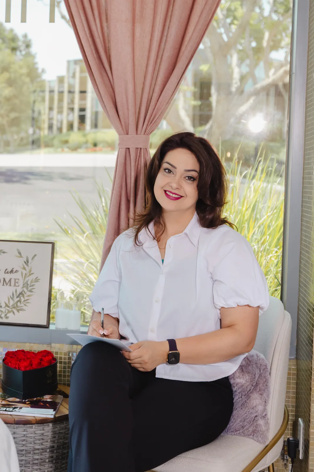 Kiana seated in a white blouse inside her skincare studio